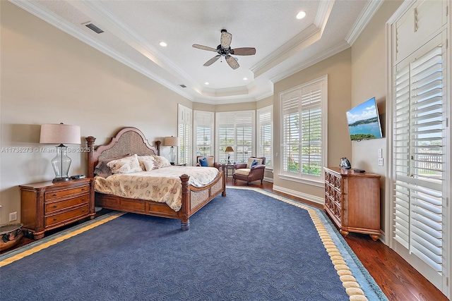 bedroom with crown molding, dark hardwood / wood-style floors, ceiling fan, and a tray ceiling