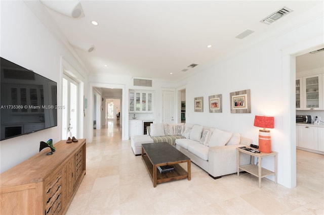 living room featuring wine cooler, ornamental molding, and indoor bar