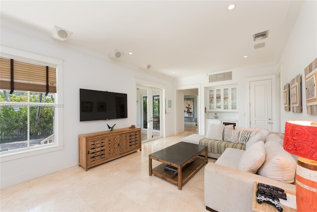 living room featuring crown molding, indoor bar, and french doors