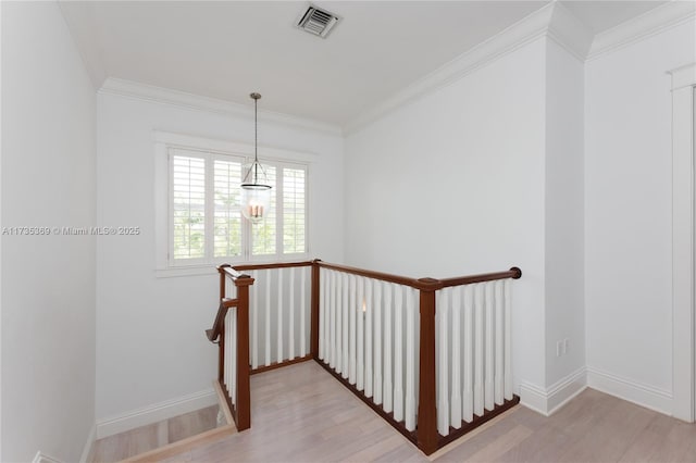 staircase featuring wood-type flooring and ornamental molding