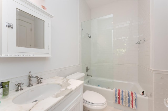 full bathroom featuring tiled shower / bath, vanity, and toilet