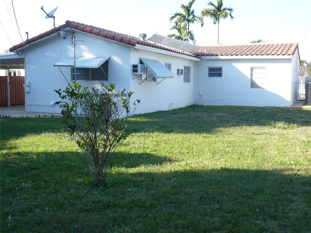 rear view of house featuring a yard