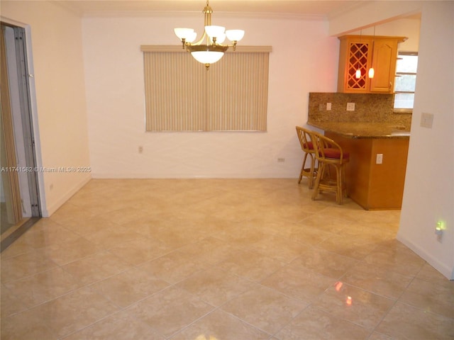 unfurnished dining area with ornamental molding and an inviting chandelier