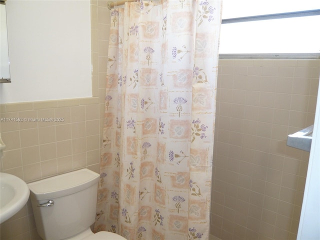 bathroom featuring walk in shower, tile walls, and toilet