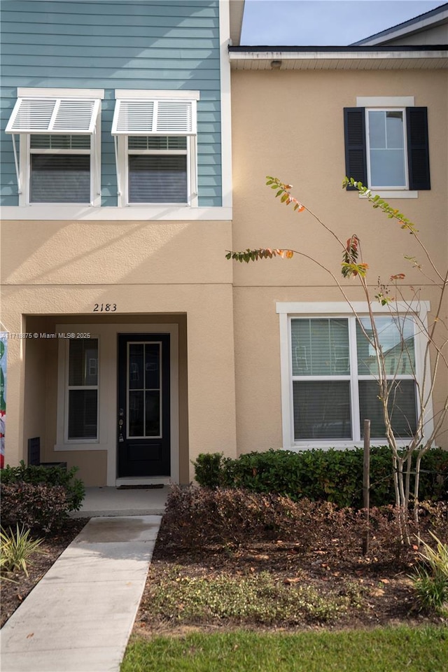 entrance to property with stucco siding and covered porch