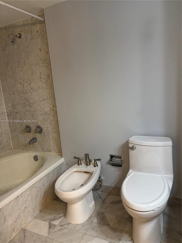 bathroom with toilet, marble finish floor, tiled shower / bath, and a bidet