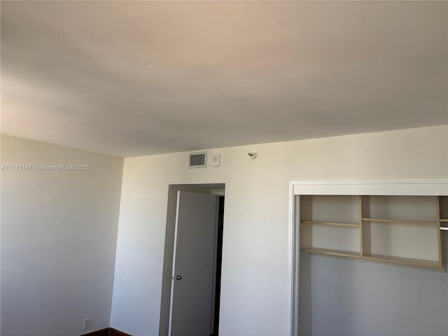 unfurnished bedroom featuring visible vents and a closet