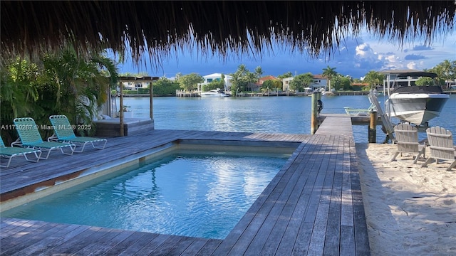 view of pool with a water view and a boat dock