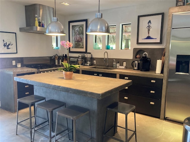 kitchen with pendant lighting, sink, a breakfast bar, built in refrigerator, and a center island