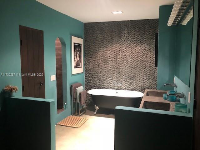 bathroom featuring radiator heating unit, sink, and a washtub