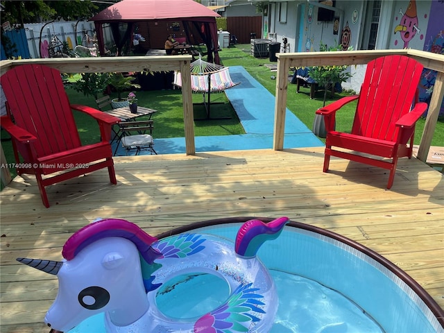 exterior space featuring a gazebo, a deck, and a jacuzzi