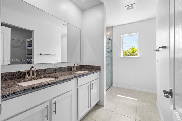 bathroom with vanity, tile patterned floors, a textured ceiling, and a shower with shower door