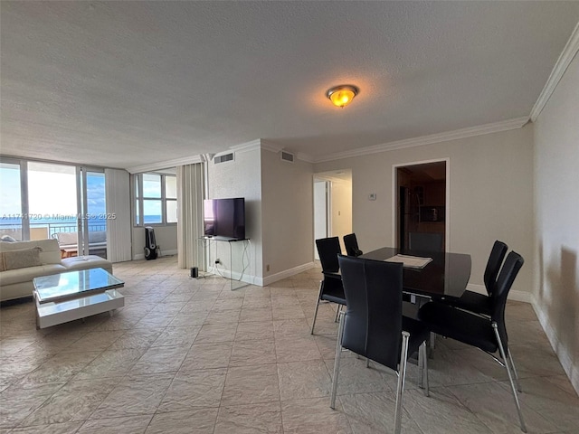 dining room featuring crown molding, a textured ceiling, and a water view