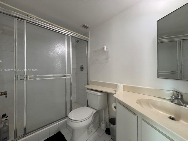 bathroom with vanity, tile patterned flooring, a shower with door, and toilet