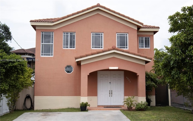 mediterranean / spanish house featuring a front lawn