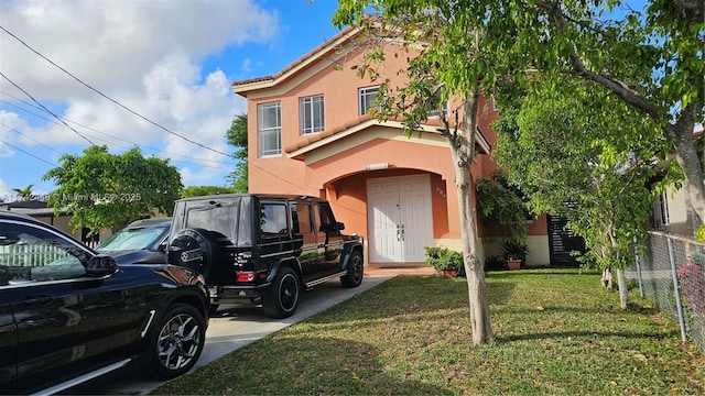 view of front facade with a front lawn, fence, and stucco siding