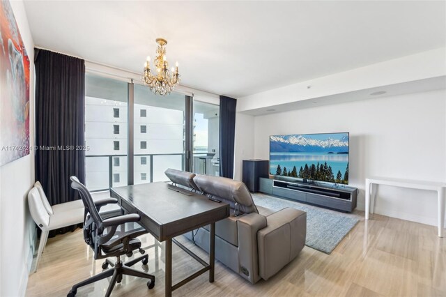 office featuring light wood-type flooring, an inviting chandelier, and expansive windows