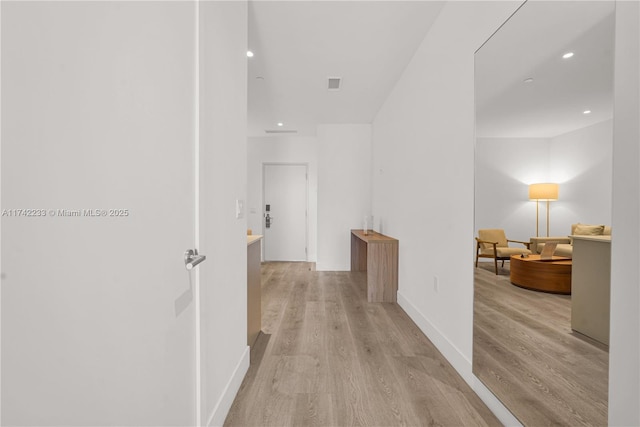 hallway with light hardwood / wood-style flooring