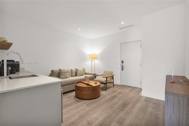 living room with sink and light wood-type flooring