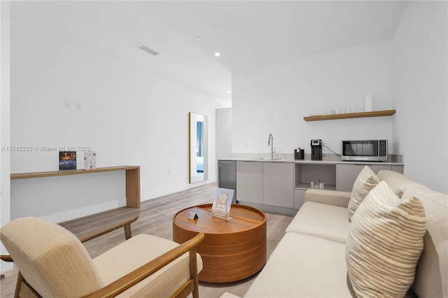 living room with sink and light wood-type flooring