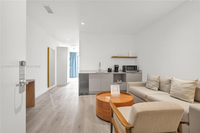 living room with sink and light hardwood / wood-style flooring