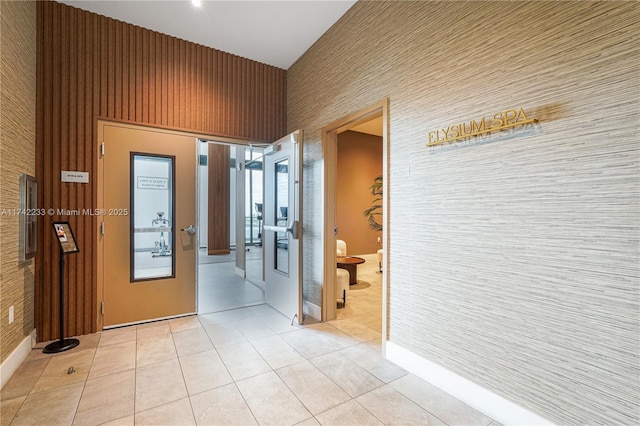 hall featuring a high ceiling and light tile patterned floors