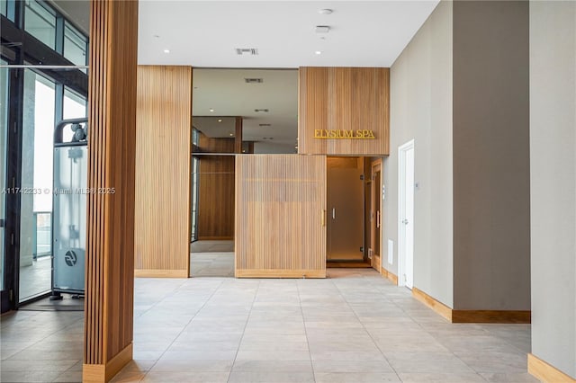 hall with a towering ceiling and light tile patterned floors