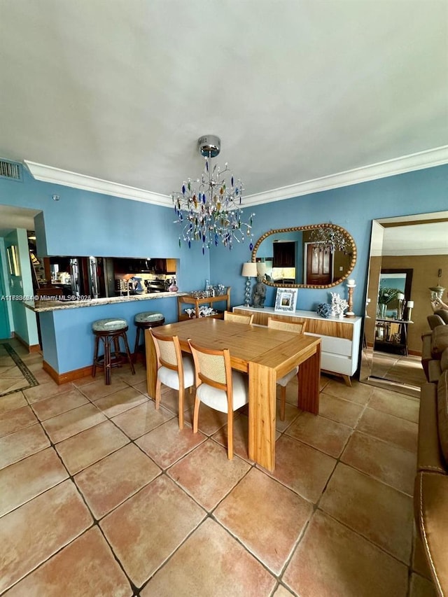 tiled dining area featuring a notable chandelier and ornamental molding