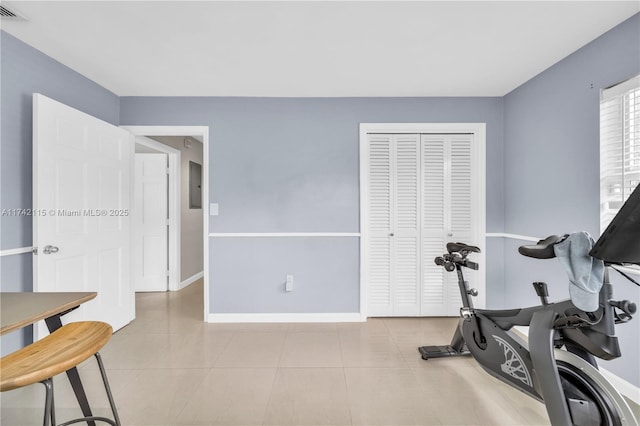 workout room featuring light tile patterned flooring and electric panel