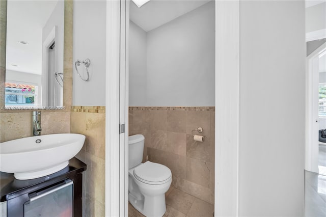 bathroom with tile patterned flooring, vanity, tile walls, and toilet