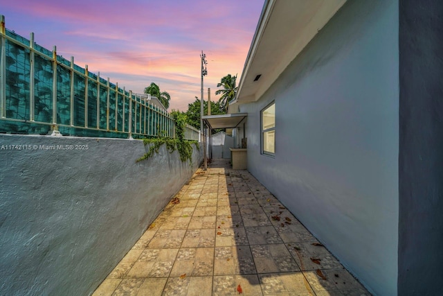 property exterior at dusk featuring a patio area