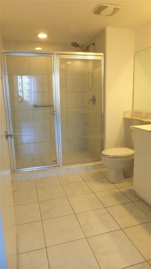 bathroom featuring vanity, toilet, and a shower with door