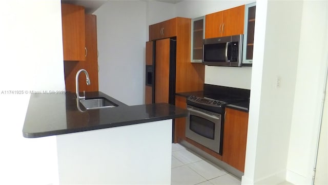 kitchen featuring sink, light tile patterned floors, stainless steel appliances, and kitchen peninsula