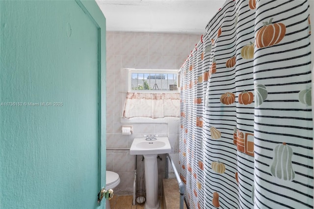 bathroom featuring tile walls, toilet, and walk in shower