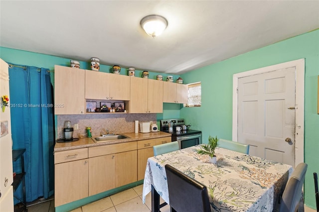 kitchen with sink, light tile patterned floors, electric range, tasteful backsplash, and light brown cabinets