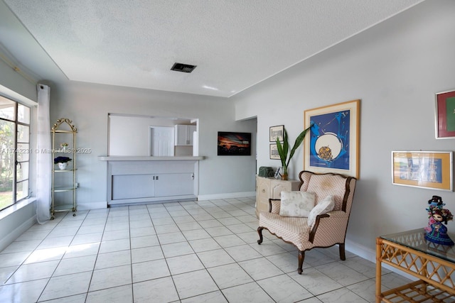 sitting room featuring light tile patterned floors and a textured ceiling