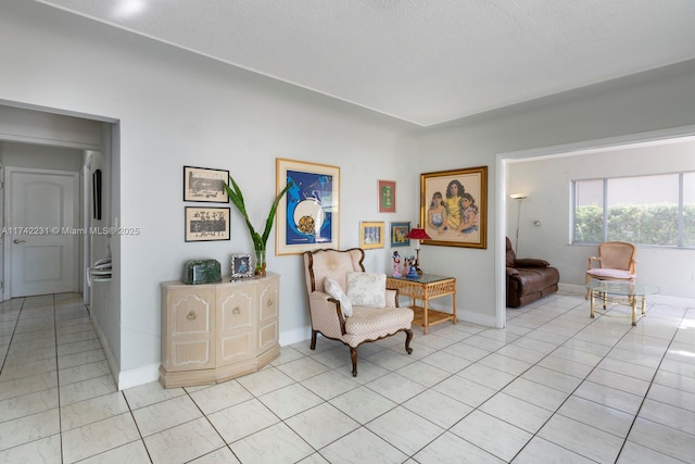 living area with light tile patterned floors and a textured ceiling