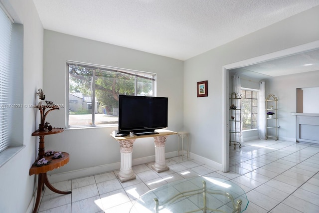 tiled living room featuring a healthy amount of sunlight and a textured ceiling