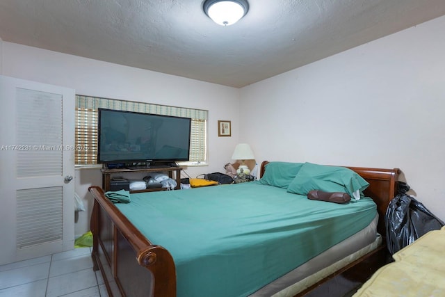 tiled bedroom featuring a textured ceiling