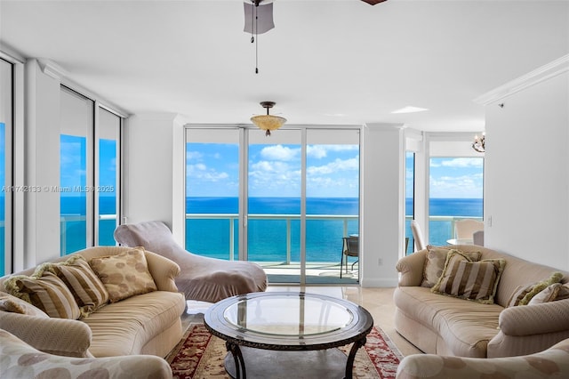 living room with a water view, ornamental molding, and expansive windows