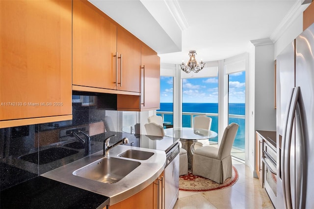 kitchen featuring a water view, crown molding, a notable chandelier, stainless steel appliances, and decorative backsplash