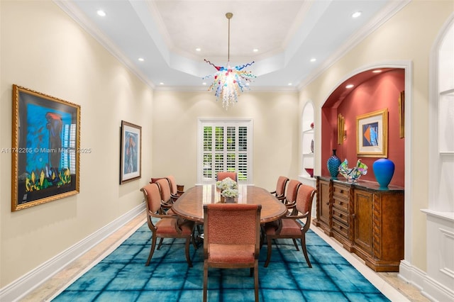 dining area featuring a raised ceiling, crown molding, and an inviting chandelier