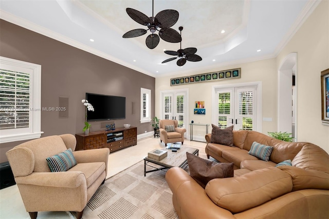 living room featuring crown molding, ceiling fan, a raised ceiling, and french doors