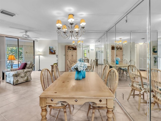 dining space with light tile patterned flooring, floor to ceiling windows, and ceiling fan with notable chandelier