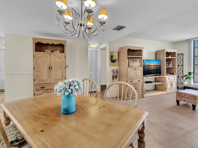 tiled dining room featuring a chandelier