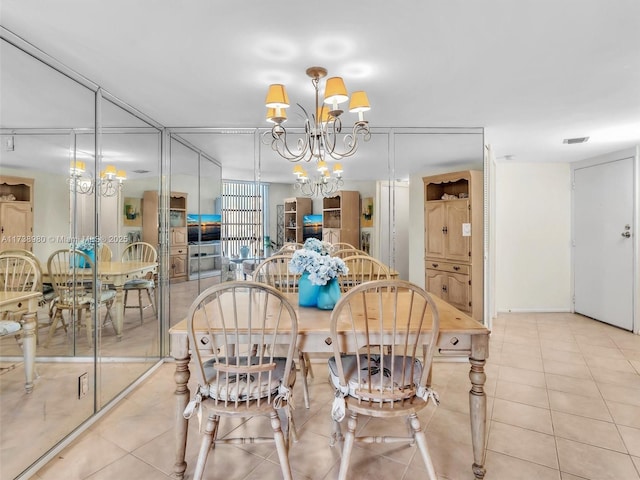 dining room with light tile patterned floors and a notable chandelier