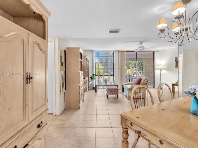 dining space featuring expansive windows, ceiling fan with notable chandelier, and light tile patterned floors