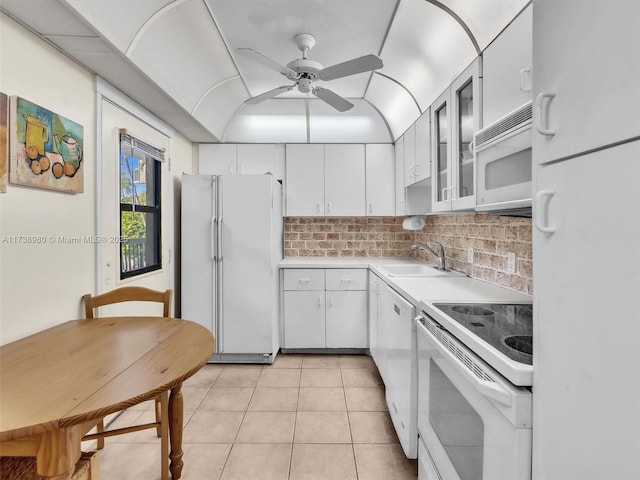 kitchen featuring white cabinetry, sink, white appliances, and light tile patterned floors