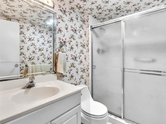 bathroom featuring vanity, toilet, and walk in shower