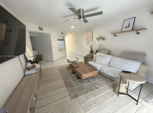 living room with ceiling fan and light hardwood / wood-style flooring